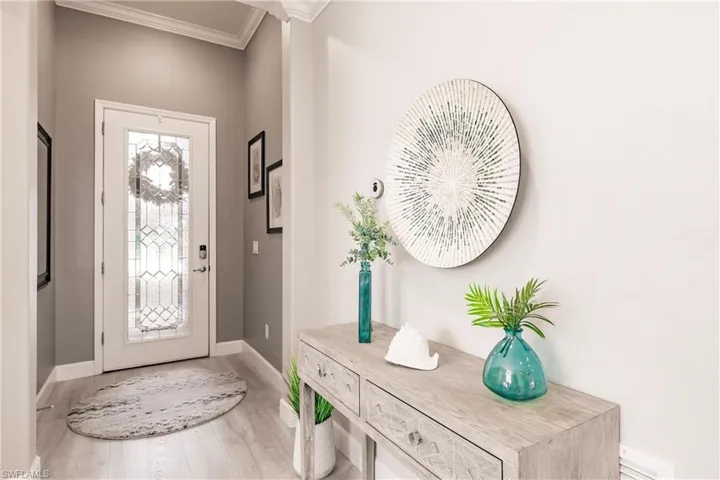 Foyer entrance with crown molding and hardwood / wood-style flooring