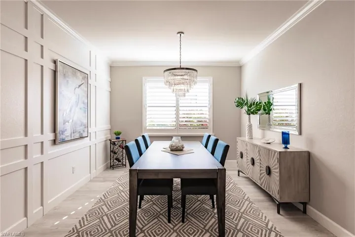 Dining space featuring a notable chandelier, ornamental molding, and light hardwood / wood-style floors