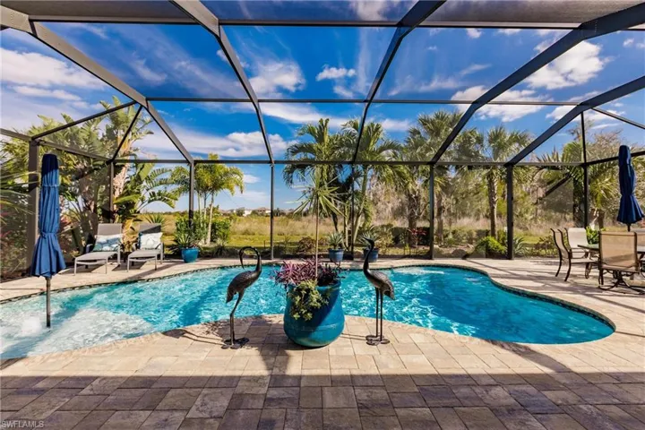 View of pool with a patio and glass enclosure