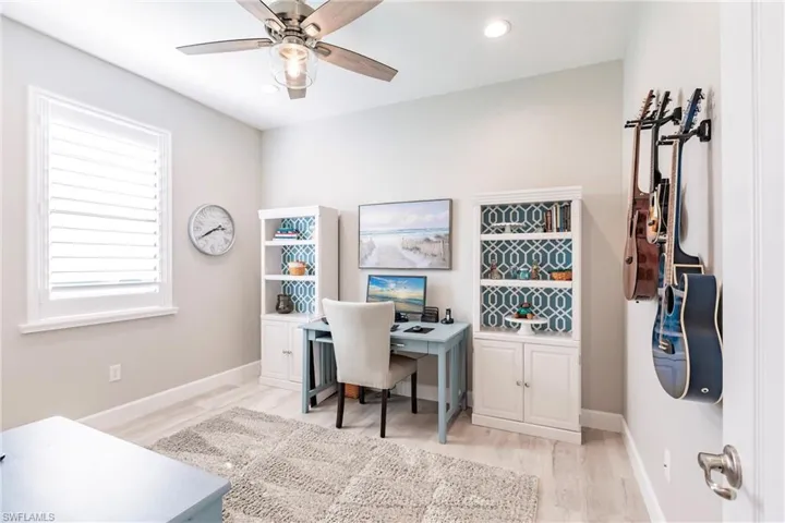 Home office with ceiling fan and light wood-type flooring