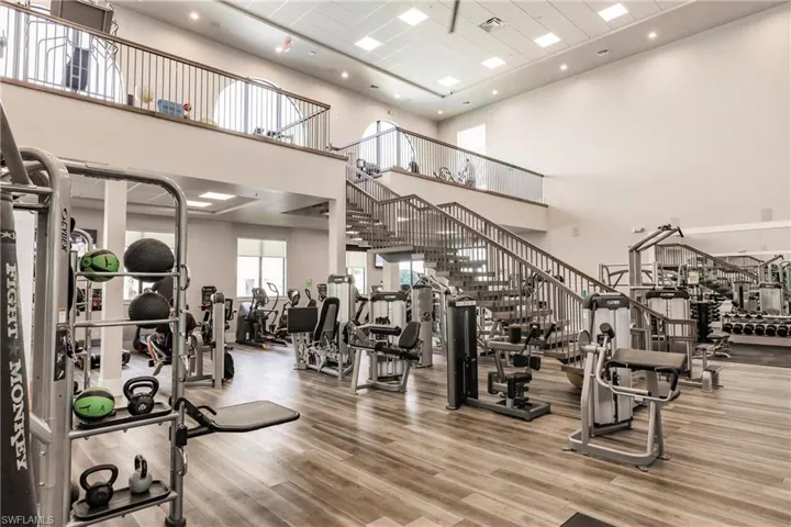 Gym featuring hardwood / wood-style floors and a high ceiling