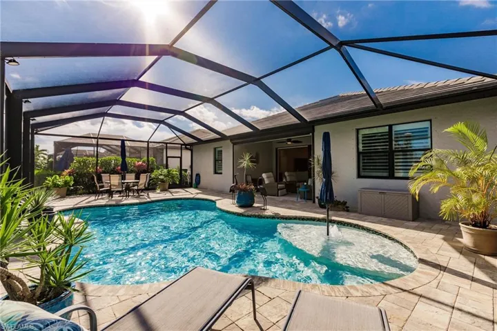 View of pool featuring a patio area and glass enclosure