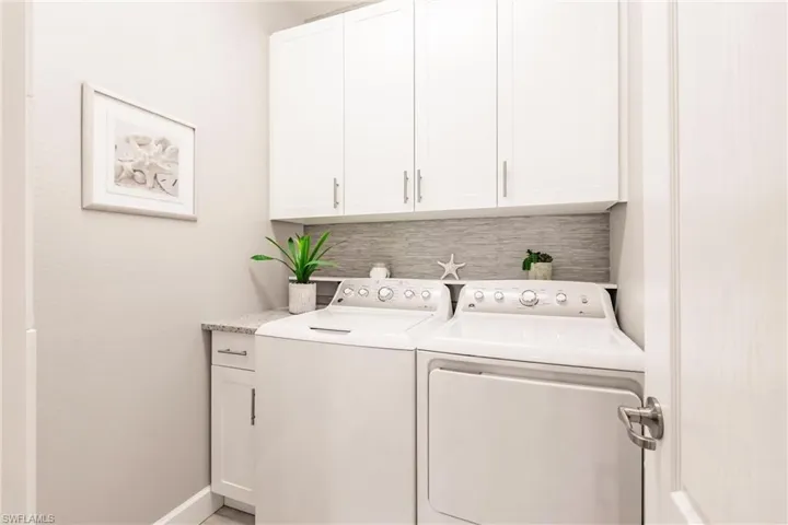 Clothes washing area with cabinets and washer and dryer