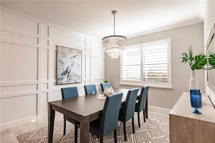 Dining room with crown molding, a chandelier, and light hardwood / wood-style floors