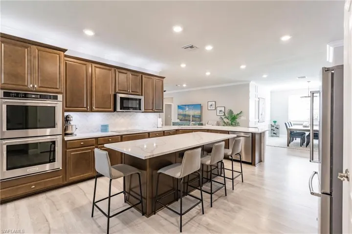Kitchen with a center island, stainless steel appliances, kitchen peninsula, and a kitchen bar