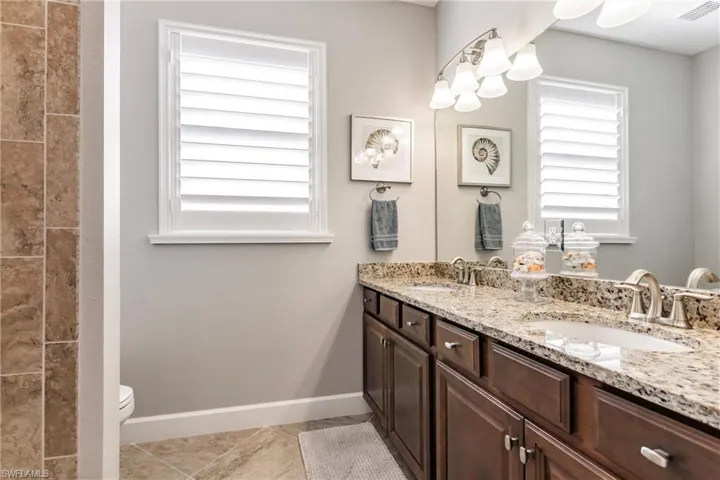 Bathroom featuring vanity, tile patterned flooring, and toilet