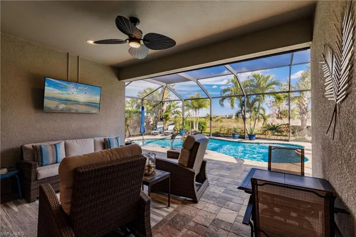 View of patio with an outdoor living space, a lanai, and ceiling fan
