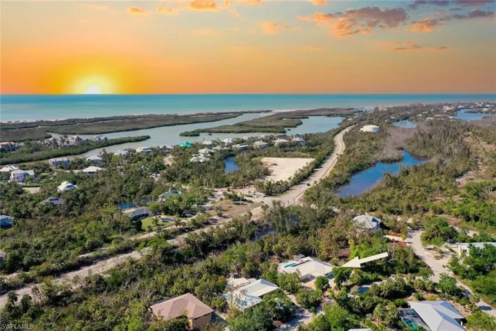 Aerial perspective featuring coastal surroundings, mature tropical vegetation, and prominent proximity to water