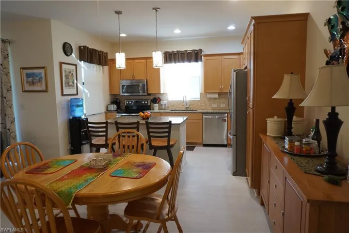 Kitchen with decorative backsplash, a center island, pendant lighting, stainless steel appliances, and recessed lighting