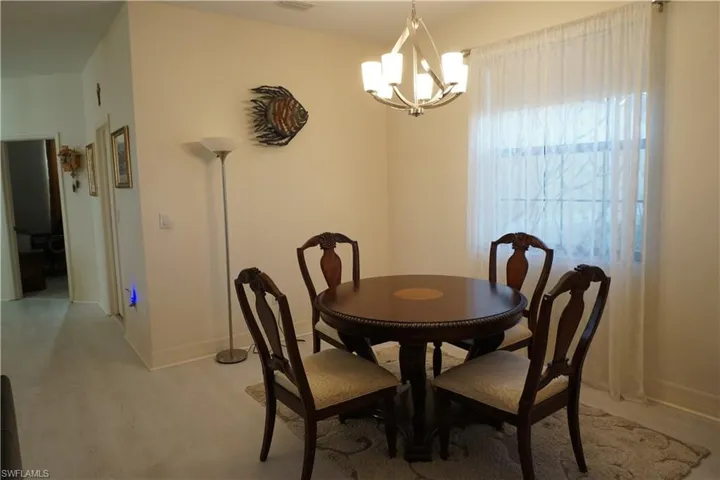 Dining room featuring light wood plank LVP flooring and a chandelier
