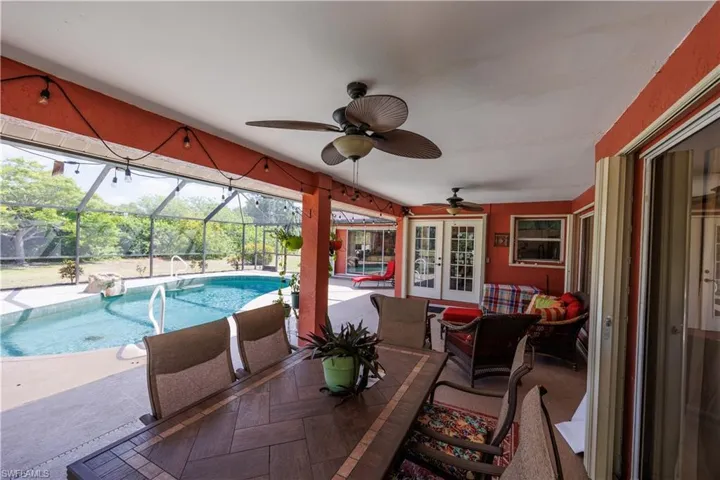 View of patio / terrace featuring glass enclosure, outdoor lounge area, french doors, a ceiling fan, and an outdoor pool