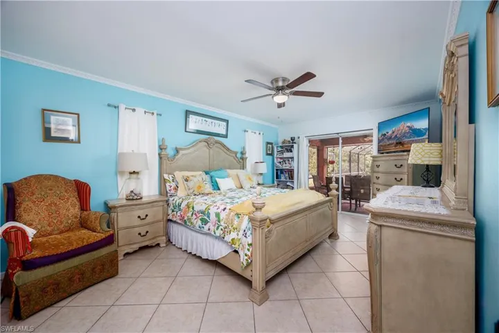 Bedroom featuring light tile patterned floors, ceiling fan, ornamental molding, and access to exterior