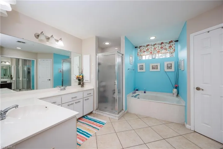 Bathroom featuring visible vents, a shower stall, a bath, and vanity