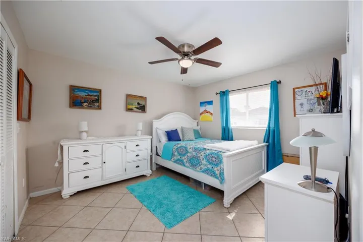 Bedroom featuring light tile patterned floors, ceiling fan, a closet, and baseboards
