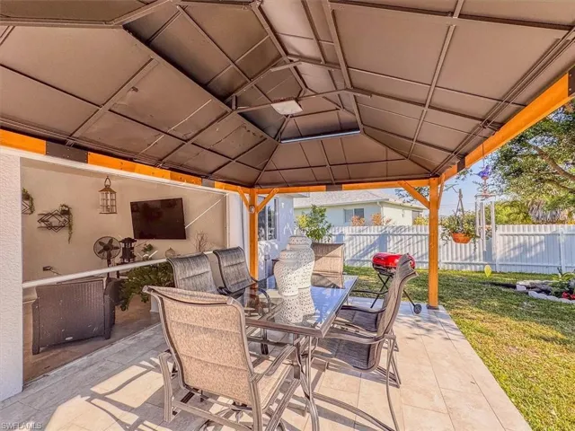View of patio / terrace featuring a gazebo, outdoor dining area, and fence