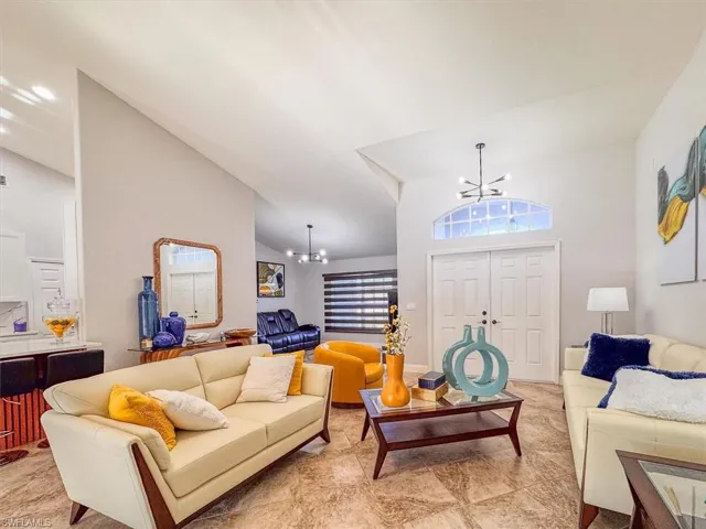 Living area featuring a notable chandelier and high vaulted ceiling