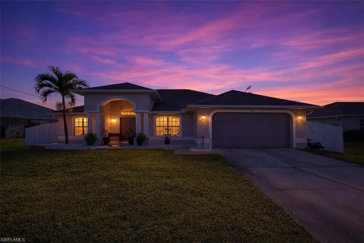 View of front of property featuring a garage, stucco siding, and driveway
