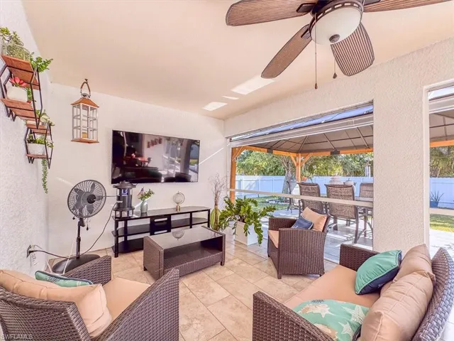 View of patio with an outdoor living space, outdoor dining area, fence, and a ceiling fan