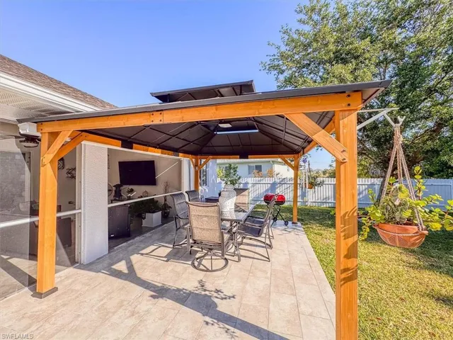 View of patio / terrace with a gazebo, outdoor dining area, and fence