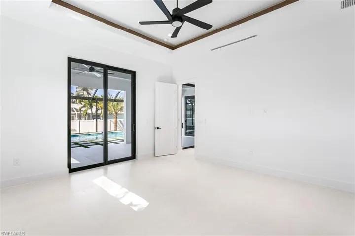 SPACIOUS PRIMARY BEDROOM is true RETREAT! Impact-resistant sliding doors to backyard oasis patio, LED recessed lights, designer's fan, and solid wood doors.