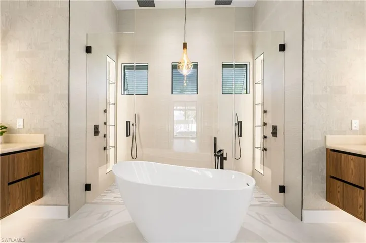 LUXURIOUS PRIMARY BATH w/ FULL GLASS WALL, DOUBLE RAINFALL SHOWERS w/ 4 jets & handheld showerheads