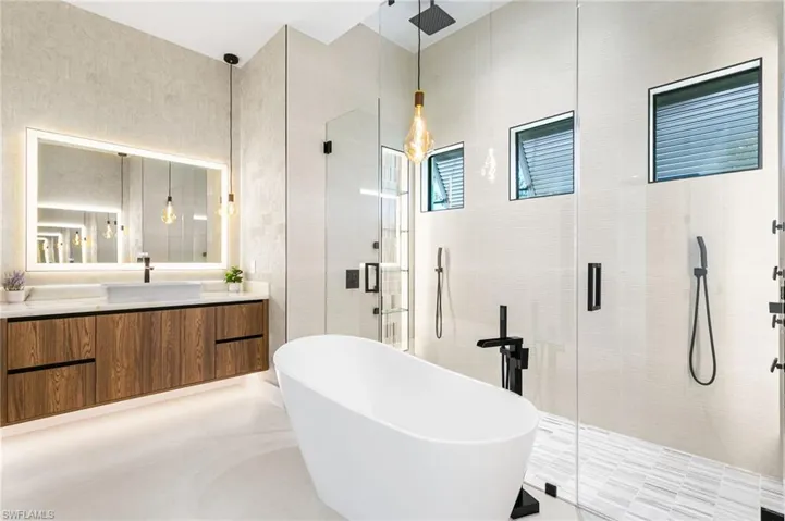 This luxurious primary bathroom features exquisite finishes, a soaking tub, and a spacious walk-in shower, creating the perfect retreat for relaxation and rejuvenation.