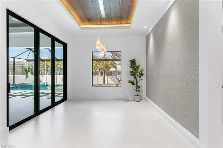STYLISH FORMAL DINING ROOM w/ HANDCREAFTED ITALIAN EMBROIDED WALLPAPER, FLAT WOODEN CEILING, designer lighting, TINTED SLIDING DOORS leading to SCREENED LANAI & large PICTURE WINDOW offer views of POOL/SPA.