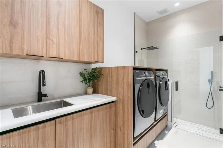 Laundry features CLEANING STATION for YOU & FURRY MATES, SAMSUNG washer & dryer, laundry tub w/ full backsplash & storage cabinets.