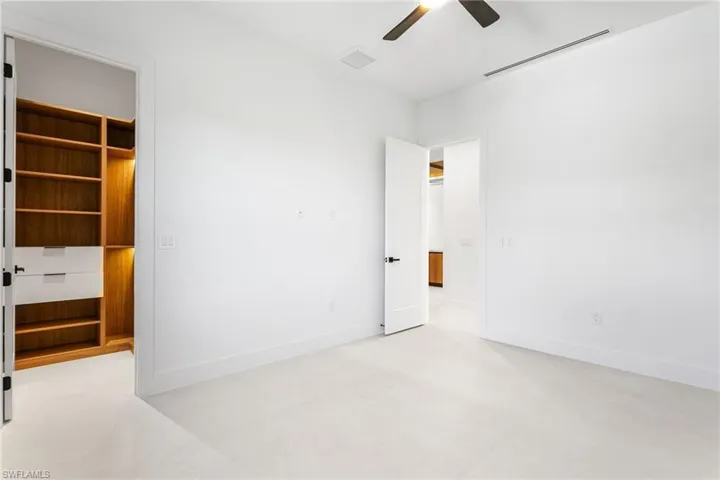 Fourth Guest Bedroom with custom full wall wraparound cabinetry in the closet.