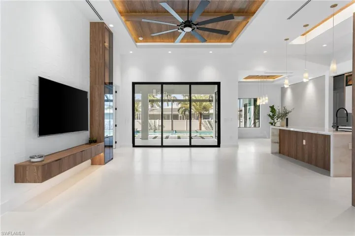 ENTER FRONT-COLUMN PORCH w/ OVERSIZED WRAPAROUND IMPACT-RESISTANT GLASS WALL into IMPRESSIVE FOYER w/ stylish ACOUSTIC PANELING FLOWING into LATERAL WALLS, complemented by 10-ft DOUBLE-TINTED DOORS.