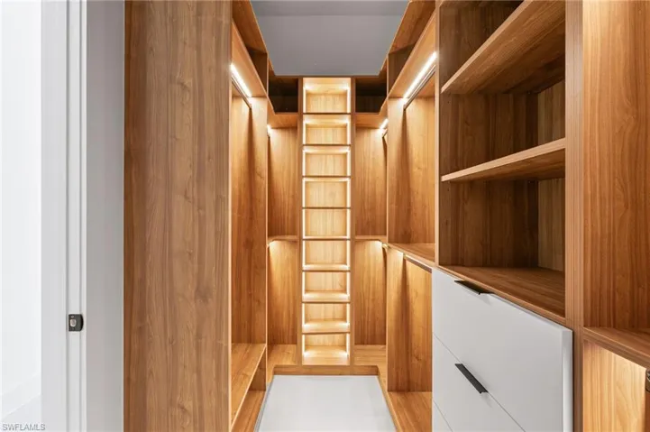 HIS-&-HER walk-in CLOSETS w/ FULL WALL custom WRAPAROUND LIGHTED CABINETRY.