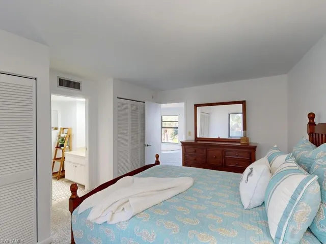 Bedroom featuring ensuite bathroom, carpet, and two closets