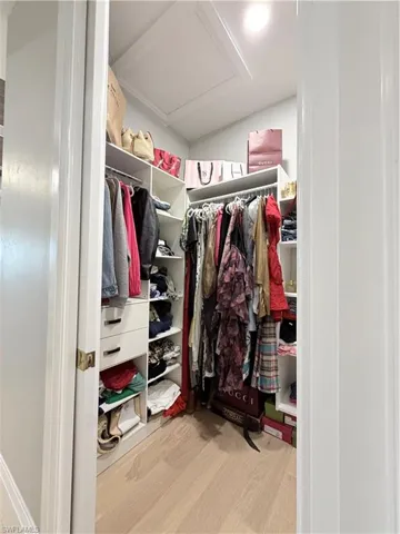Spacious closet with light wood-style floors and attic access