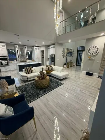 Living area with wood tiled floors, a high ceiling, and recessed lighting