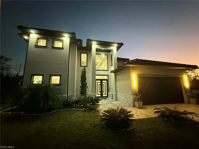 View of front facade with an attached garage, stucco siding, and driveway