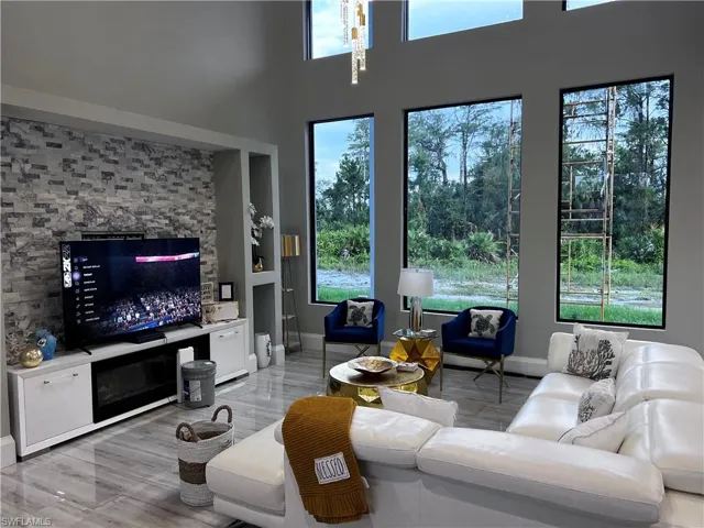 Living room featuring baseboards and a high ceiling