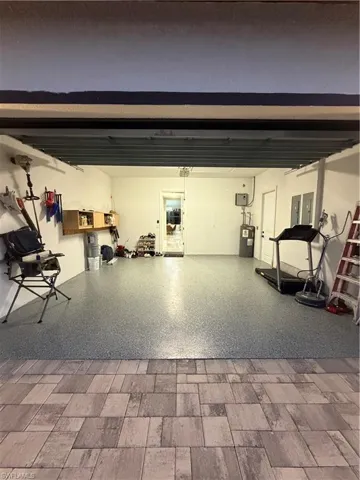 Garage featuring water heater and electric panel