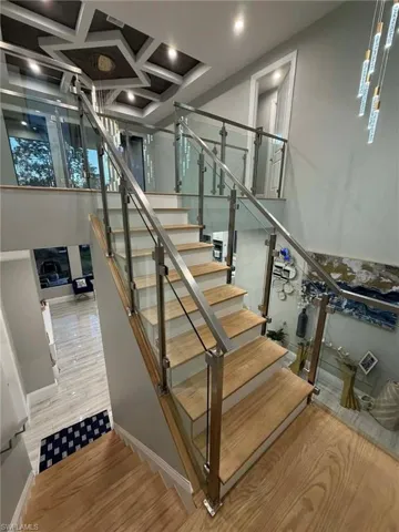 Stairs featuring wood finished floors, coffered ceiling, and recessed lighting