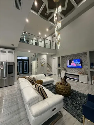 Living room with light wood-type flooring and high coffered ceiling