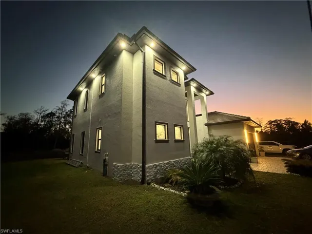 View of property exterior featuring a yard, stone siding, and stucco siding