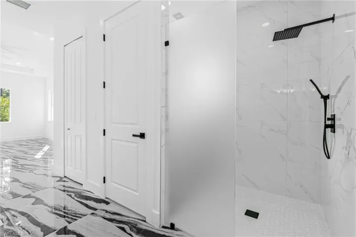 Bathroom featuring a marble finish shower, marble tiled flooring, and recessed lighting