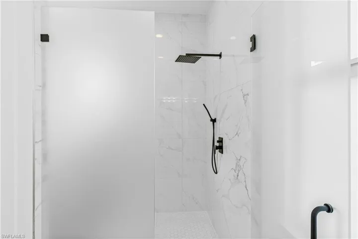 Full bathroom with a marble finish shower