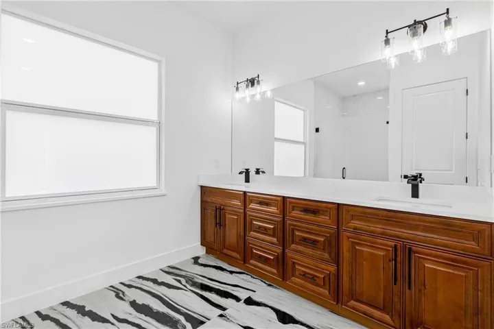Full bath featuring a stall shower and double vanity