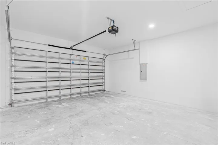 Garage featuring electric panel and a garage door opener