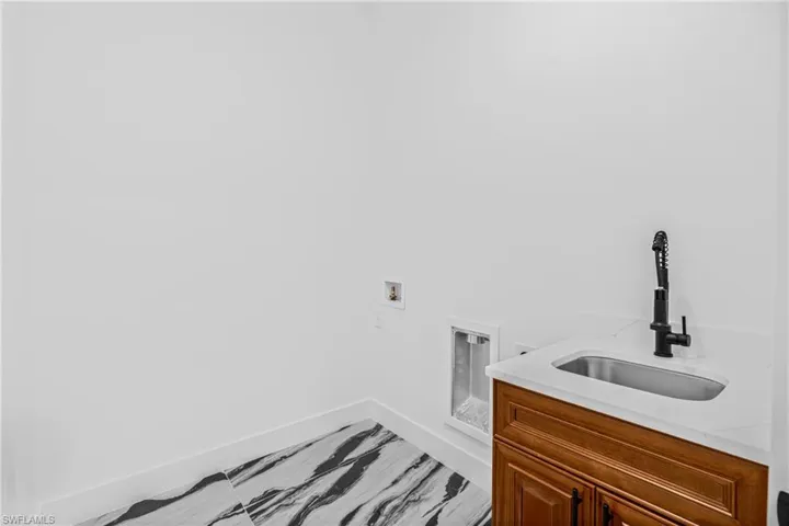 Laundry room featuring washer hookup and cabinet space