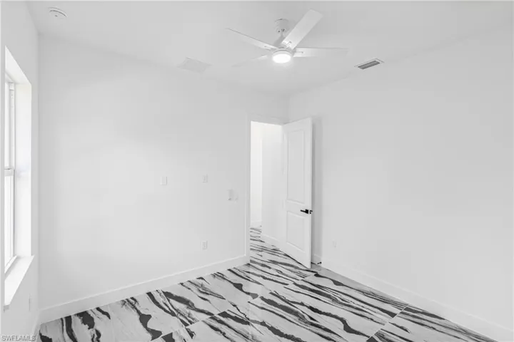 Empty room with a ceiling fan and baseboards