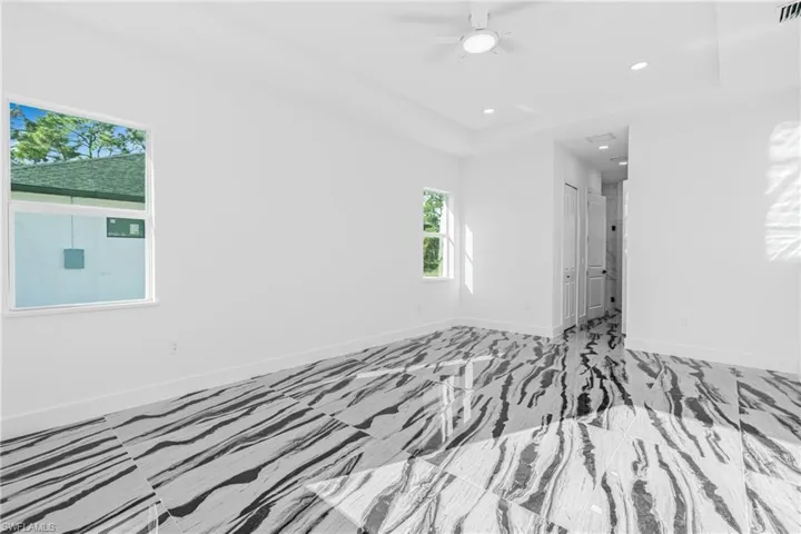 Spare room featuring recessed lighting, a raised ceiling, and a ceiling fan