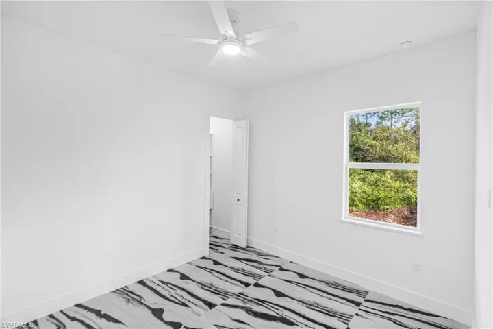 Spare room featuring baseboards and ceiling fan