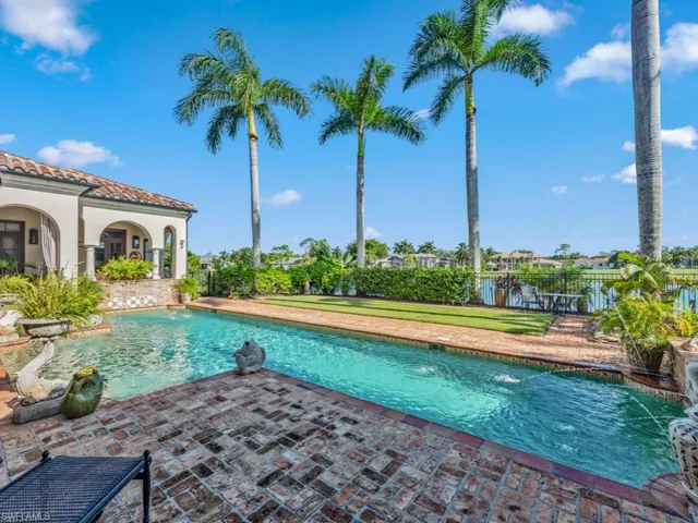 View of swimming pool featuring pool water feature and a patio
