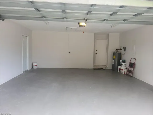 Garage featuring a garage door opener and water heater